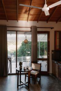 a living room with a table and a balcony at Django Villa Weligama in Weligama