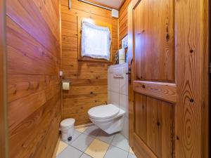 a bathroom with a toilet and wooden walls at das Sopherl in Sonnenalpe Nassfeld