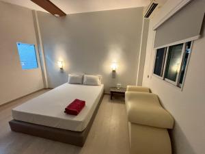 a small bedroom with a bed and a chair at Picnic Si Racha in Ban Fang Daeng