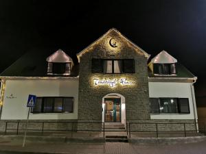 a brick building with a sign on it at night at Tündérliget in Egerszalók