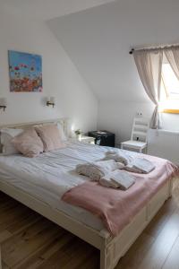 a bedroom with a large white bed with a window at Tündérliget in Egerszalók
