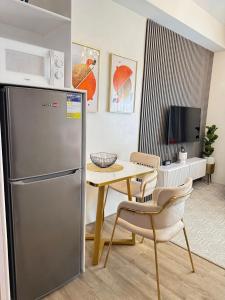 a kitchen with a stainless steel refrigerator and a table at Ona's Condo in Bacolod