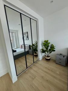 a large mirror in a room with a bedroom at 37 Syward Place in Chertsey