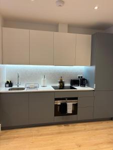 a kitchen with white cabinets and a sink at 37 Syward Place in Chertsey