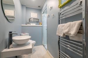 a bathroom with a white sink and a mirror at Bakers Close - Elie in Elie +17 photos