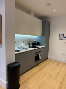 a kitchen with white cabinets and a trash can at 37 Syward Place in Chertsey +15 photos