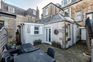 a patio with a table in front of a building at Bakers Close - Elie in Elie