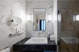a bathroom with a sink and a mirror at Le Stendhal - Vendôme in Paris +42 photos
