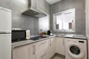 a kitchen with a sink and a washing machine at Apartaments S'Estanyol in La Savina +94 photos