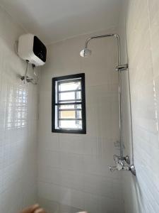 a shower in a bathroom with a window at The NookHouse in Calabar +80 photos