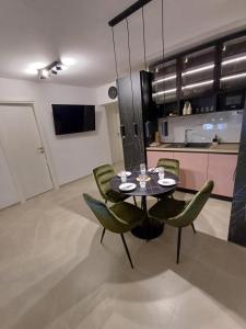 a dining room with a table and green chairs at Apartman Danijel in Bibinje