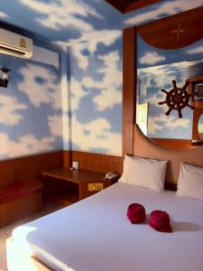 a bedroom with a bed with two red roses on it at Picnic Si Racha in Ban Fang Daeng +10 photos