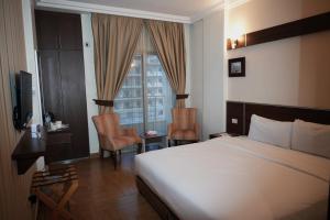 a bedroom with a bed and two chairs and a window at Ream Hotel Amman in Amman +157 photos