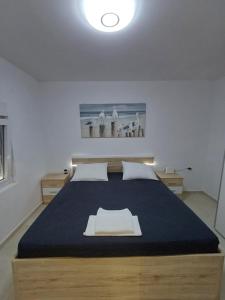 a bedroom with a large bed with a blue blanket at Apartman Danijel in Bibinje