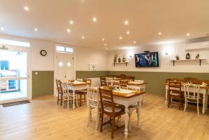 a dining room with wooden tables and chairs at Tündérliget in Egerszalók