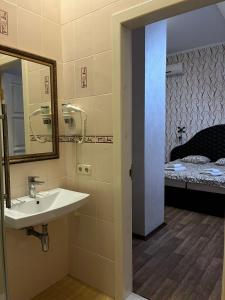 a bathroom with a sink and a mirror and a bed at Приватна садиба Фортеця Малехів in Lviv +123 photos