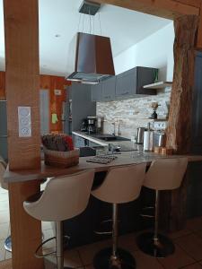 a kitchen with a counter with stools in it at Le gîte Le Marillet in Thorigny