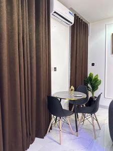 a dining room with a table and chairs and curtains at The NookHouse in Calabar