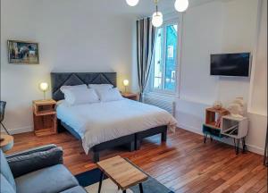a bedroom with a bed and a couch at La suite bleue in Étretat