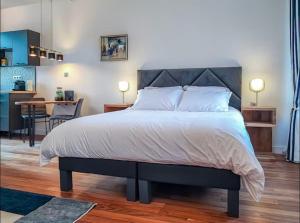 a bedroom with a large bed and a kitchen at La suite bleue in Étretat