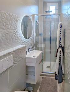 a bathroom with a sink and a shower at La suite bleue in Étretat