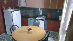 a kitchen with a table with a vase of flowers on it at Graciana Quequén in Necochea +2 photos