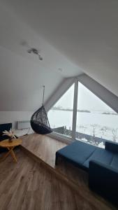 a living room with a blue couch and a large window at Riwiera Strzelecka in Strzelce Małe +34 photos