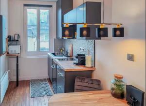 a kitchen with a counter and a table in it at La suite bleue in Étretat