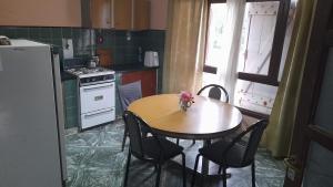 a kitchen with a table and chairs and a refrigerator at Graciana Quequén in Necochea