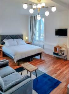 a bedroom with a large bed and a blue rug at La suite bleue in Étretat
