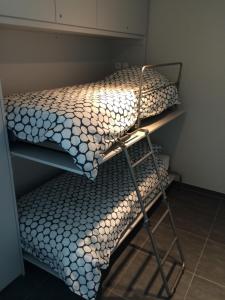 two bunk beds in a small room with a bedspread at Karthuizer Zeezicht I in Nieuwpoort