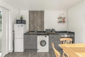 a kitchen with a washing machine and a refrigerator at Badger Haven, Apartment 2 in Brackley