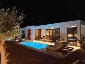 a villa with a swimming pool at night at Kudos Luxury villas in Korinthos