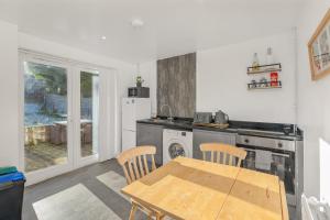 a kitchen with a wooden table and a table and chairs at Badger Haven, Apartment 2 in Brackley