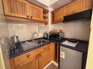 a small kitchen with wooden cabinets and a sink at Hotel del Volcán in Pucón