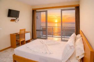 a bedroom with a bed and a view of the ocean at Cruzeiro Guest House in São Filipe