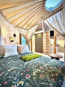 a bedroom with a bed with a floral comforter at Jurta Jura leśna in Przybysławice