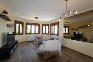 a large living room with a couch and a tv at Casa Jardin del Valle. TuCasaTemporal in Seseña