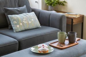 a tray with two donuts and two cups on a couch at Lakeside Lodge in Eastleigh