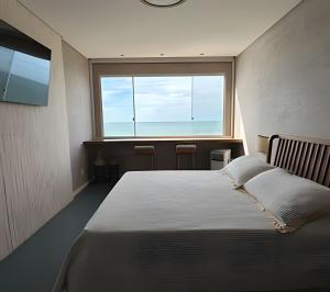 a bedroom with a bed and a large window at Guarapari Center Aparts in Guarapari +277 photos