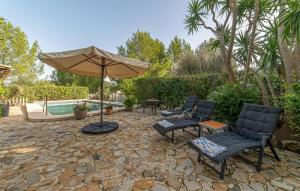 a patio with chairs and an umbrella and a pool at Can Taco in Galilea +42 photos