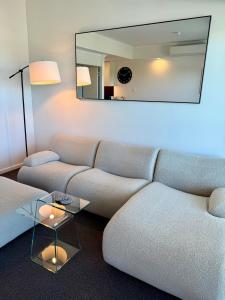 a living room with a couch and a mirror at HAVEN by the Sea in Mandurah
