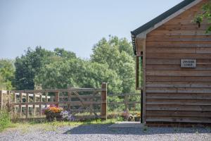 a wooden shed with a gate and a sign on it at Lakeside Lodge in Eastleigh