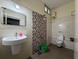 a bathroom with a sink and a toilet at Hampi Banana Farm House in Hospet +27 photos
