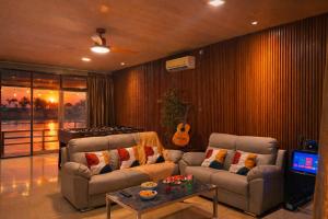 a living room with two couches and a guitar at Entire Villa, Ferry Terminal Pickup & Breakfast in Batam Center