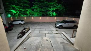 two cars parked in a parking lot at night at Apt 18 - VR Village in São Luís