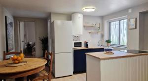 a kitchen with a table and a white refrigerator at Meu Sonho Cascais - Praia in Alcabideche
