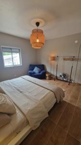 a bedroom with a large bed and a blue couch at Meu Sonho Cascais - Praia in Alcabideche