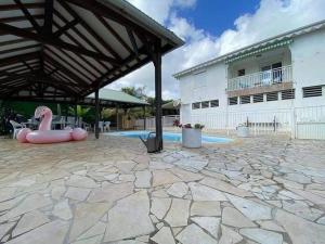 a patio with a swimming pool and a building at Charmant T2 sur le robert in Le Robert