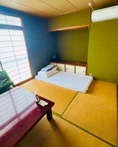 a room with a bed and a table in it at Biwa Asahi 家族友人大人数ok BBQok in Takashima